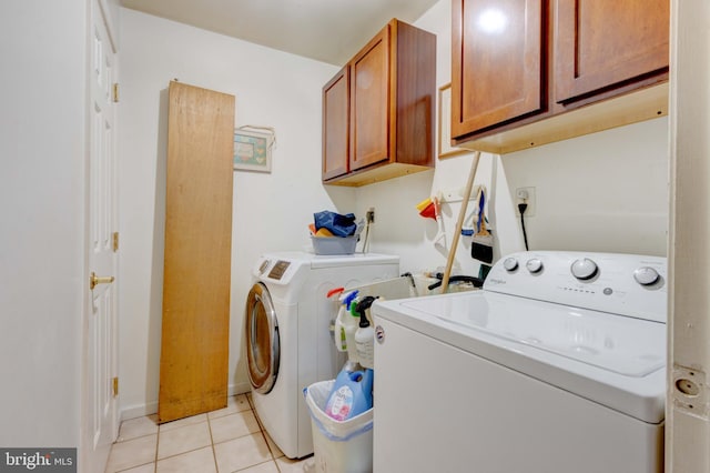 laundry room with washer and dryer, light tile patterned floors, and cabinet space