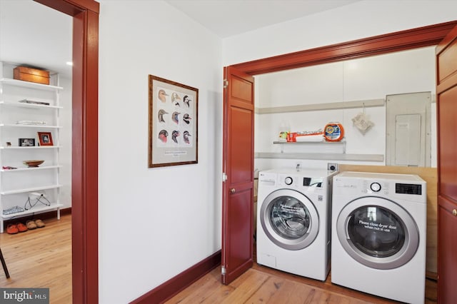 laundry area featuring laundry area, baseboards, washer and clothes dryer, and light wood finished floors