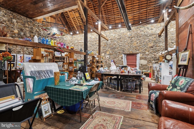 interior space with wooden ceiling, wood-type flooring, a high ceiling, and beam ceiling