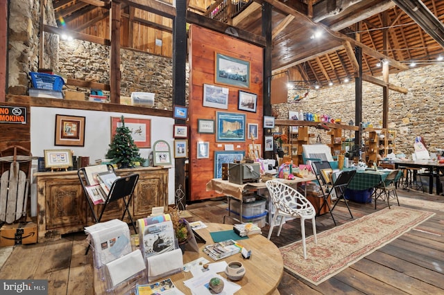 interior space with a towering ceiling, hardwood / wood-style flooring, and wooden ceiling