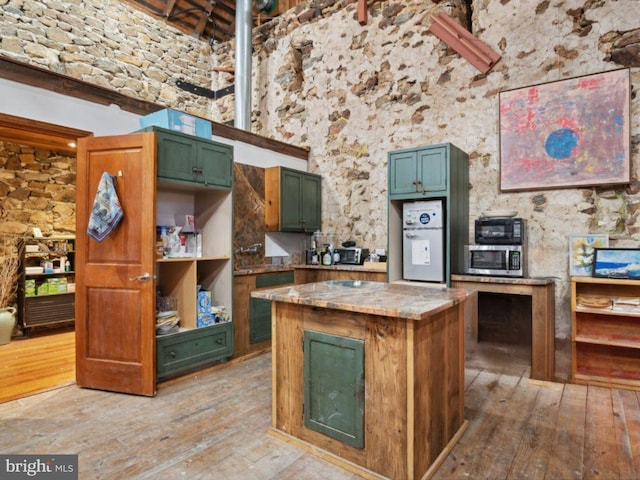 kitchen featuring light wood-style floors, stainless steel microwave, and a kitchen island