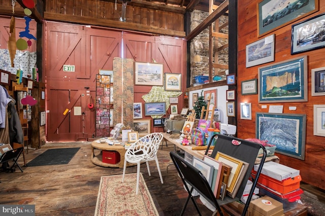 interior space with wood walls, wood finished floors, and a towering ceiling