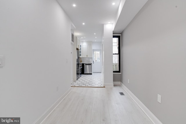 hall featuring recessed lighting, light wood-type flooring, visible vents, and baseboards