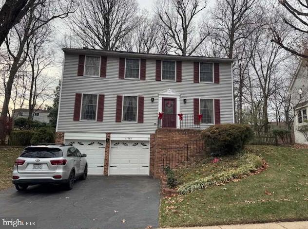 colonial inspired home featuring aphalt driveway and a garage