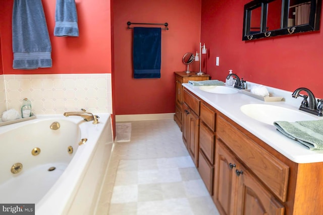 bathroom featuring double vanity, a tub with jets, a sink, and tile patterned floors