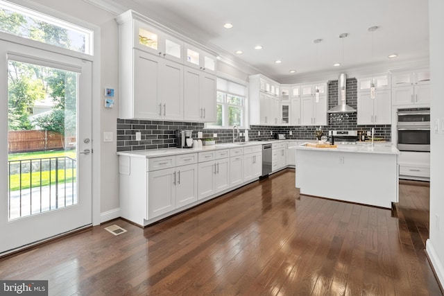 7911 Fort Hunt Rd, Alexandria, VA 22308 - kitchen with wall chimney range hood, stainless steel appliances, light countertops, dark wood finished floors, and crown molding