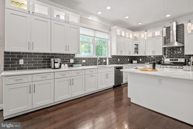 7911 Fort Hunt Rd, Alexandria, VA 22308 - kitchen featuring wall chimney range hood, appliances with stainless steel finishes, white cabinetry, dark wood-style floors, and pendant lighting