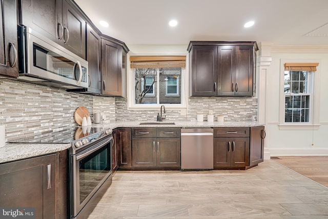 1400 Montague St NW, Washington, DC 20011 - kitchen featuring dark brown cabinetry, light stone counters, appliances with stainless steel finishes, and a sink