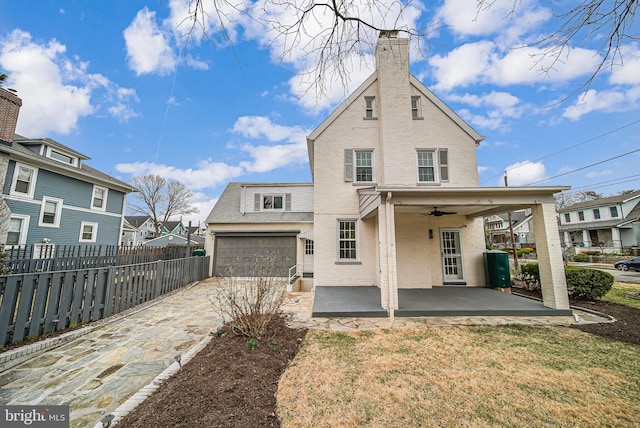 1400 Montague St NW, Washington, DC 20011 - back of house featuring fence, driveway, a chimney, ceiling fan, and brick siding
