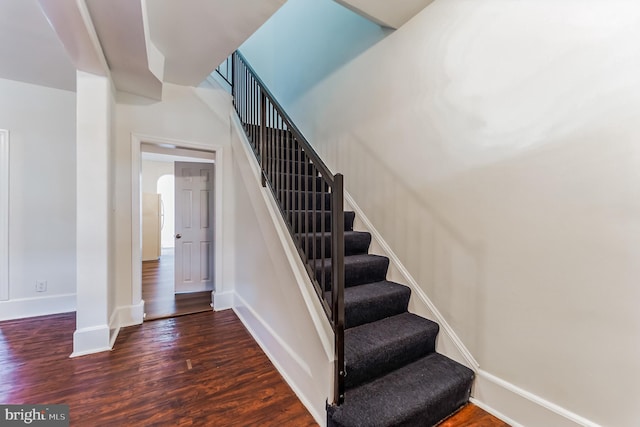 stairs with wood finished floors and baseboards