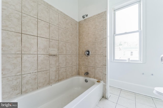 bathroom featuring toilet, bathing tub / shower combination, baseboards, and tile patterned floors