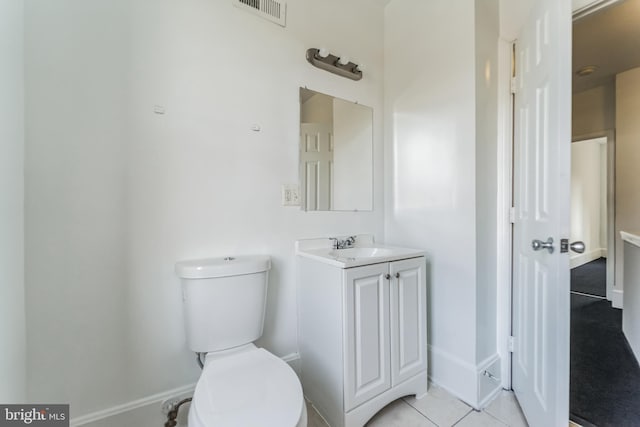 half bath with visible vents, vanity, toilet, and tile patterned floors