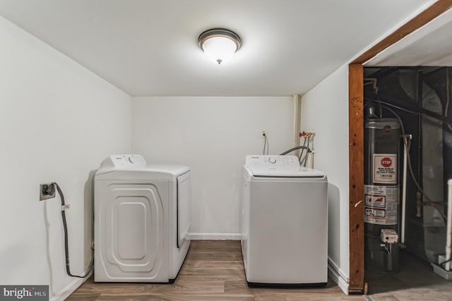 laundry room with laundry area, gas water heater, independent washer and dryer, and wood finished floors