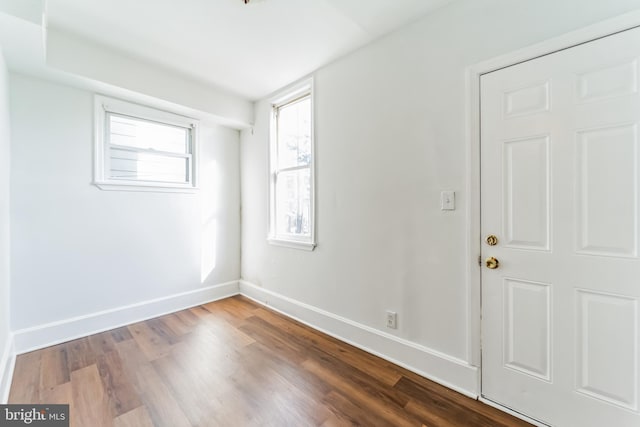 spare room featuring dark wood-style floors and baseboards