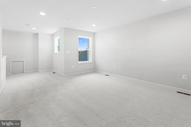 unfurnished room with recessed lighting, light carpet, visible vents, and baseboards