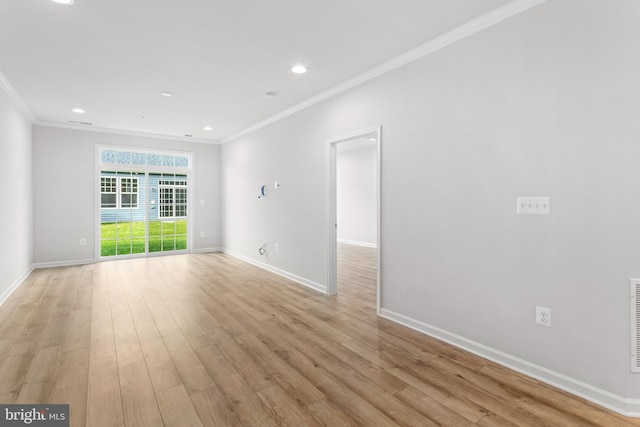 spare room featuring light wood-style floors, ornamental molding, and baseboards