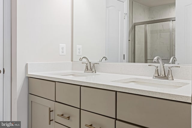 bathroom featuring a sink, a shower stall, and double vanity