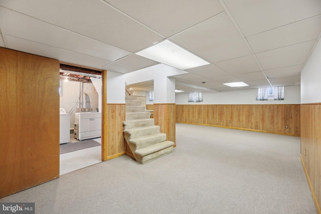 basement featuring a wainscoted wall, washer / dryer, and wooden walls