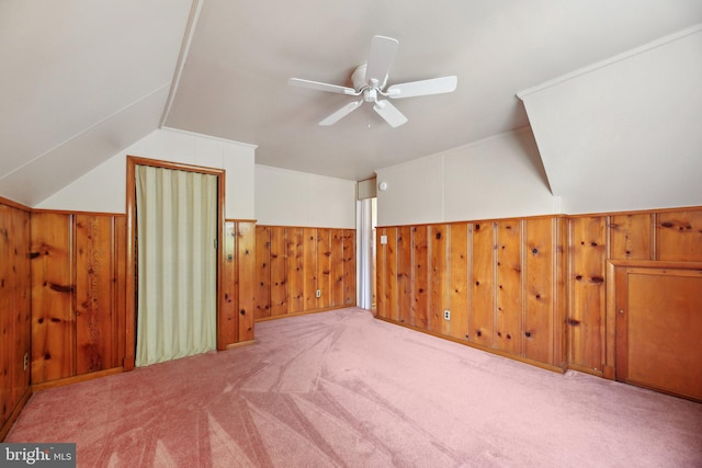 bonus room featuring wooden walls, ceiling fan, carpet, a wainscoted wall, and lofted ceiling