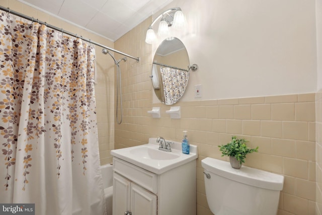 full bathroom with vanity, tile walls, toilet, and shower / bath combo with shower curtain