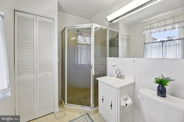 bathroom featuring a closet, toilet, and a shower stall