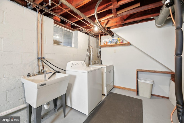 washroom with washer and dryer, laundry area, baseboards, and a sink