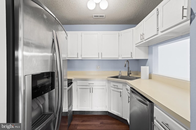 kitchen featuring a sink, visible vents, white cabinets, light countertops, and appliances with stainless steel finishes