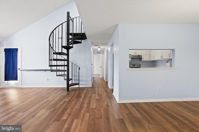 interior space with stairway, dark wood-style flooring, a textured ceiling, and baseboards