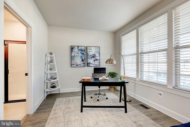 office space with visible vents, baseboards, and wood finished floors