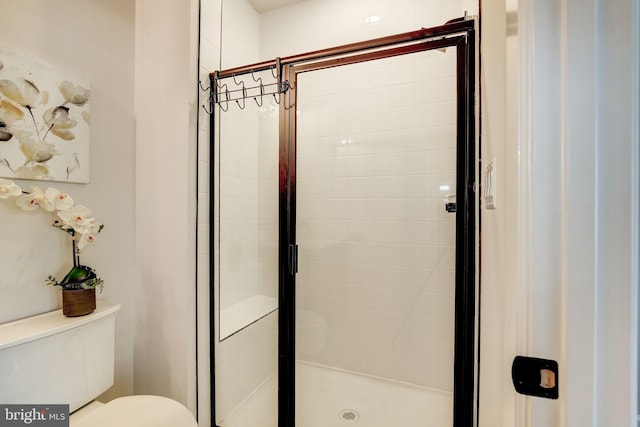 full bathroom featuring a stall shower and toilet