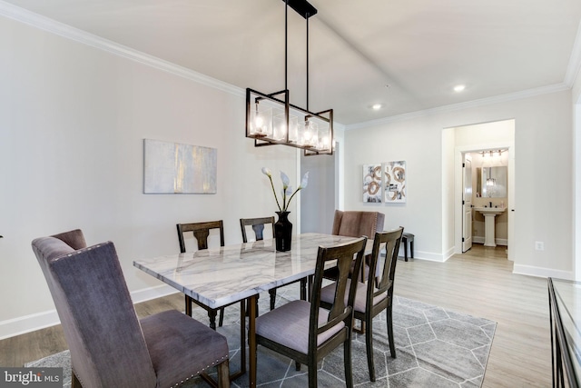 dining area featuring ornamental molding, baseboards, and wood finished floors