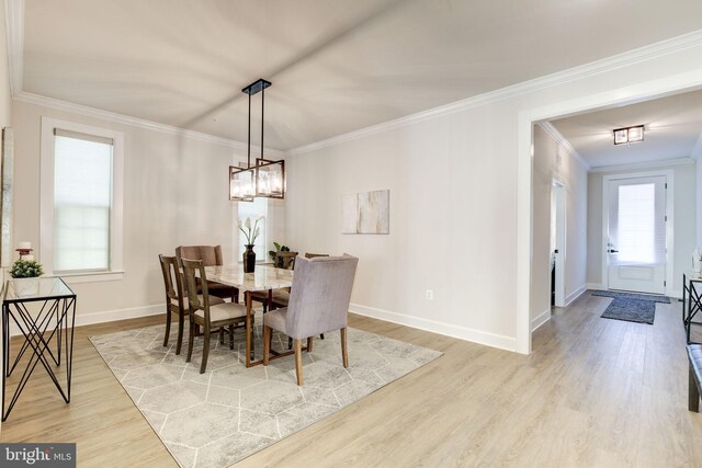 dining area with light wood-type flooring, baseboards, and ornamental molding