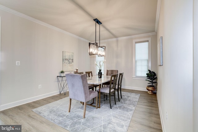 dining area featuring ornamental molding, an inviting chandelier, baseboards, and wood finished floors