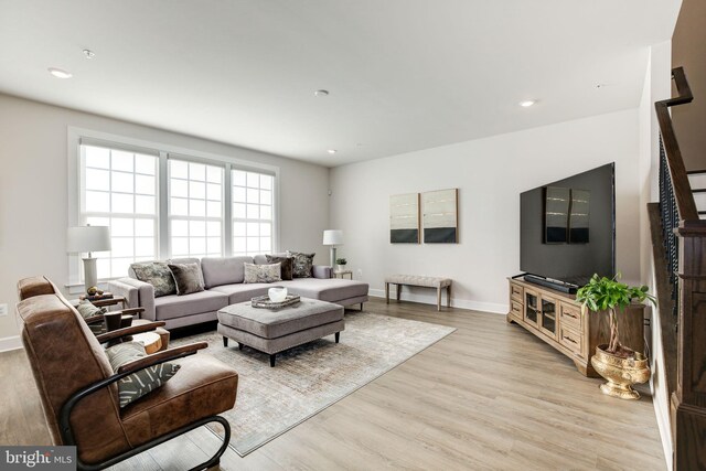 living area featuring light wood-style floors, baseboards, and recessed lighting