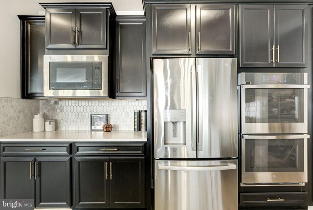 kitchen with tasteful backsplash, appliances with stainless steel finishes, and light countertops