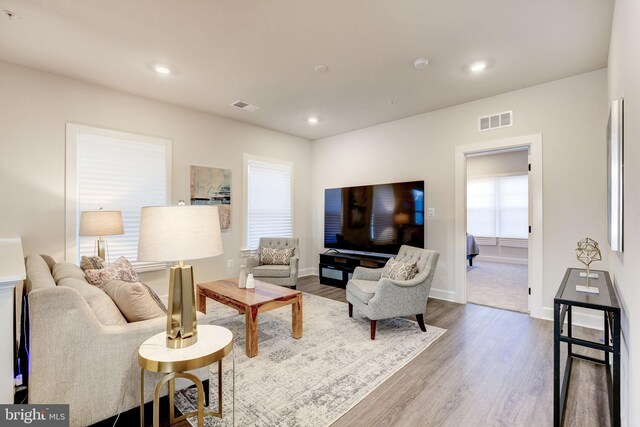 living room with visible vents, wood finished floors, and recessed lighting