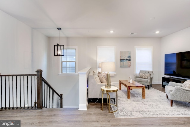 living room with recessed lighting, wood finished floors, visible vents, and baseboards