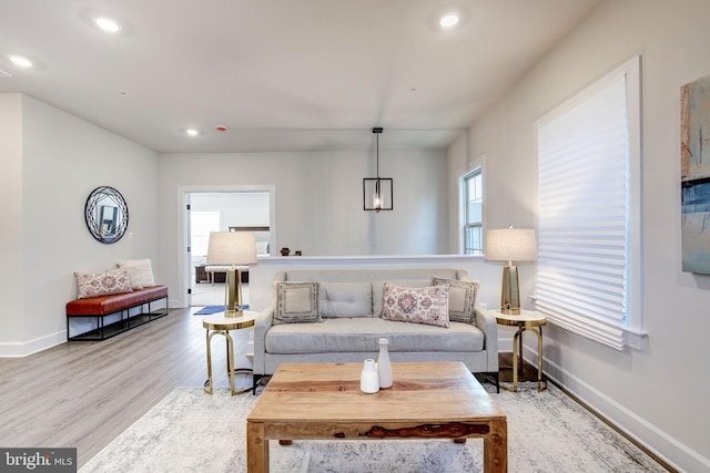 living area with baseboards, wood finished floors, and recessed lighting