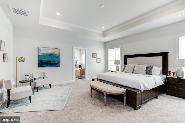 bedroom with a raised ceiling, light colored carpet, visible vents, ornamental molding, and baseboards