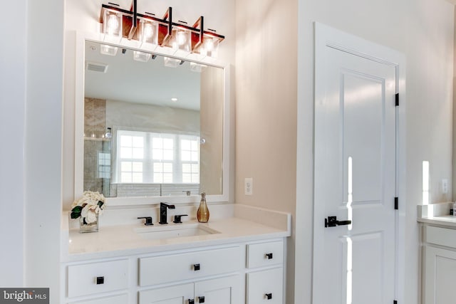 bathroom with a stall shower, visible vents, and vanity