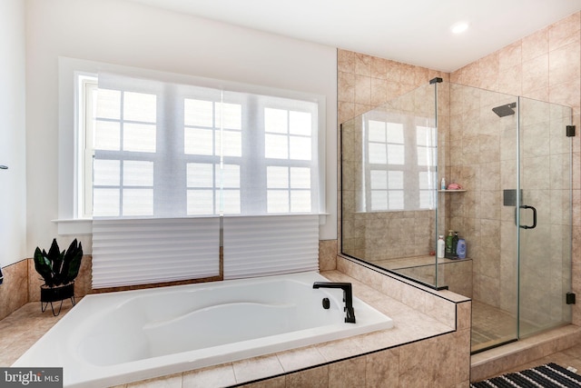 bathroom featuring a garden tub and a shower stall