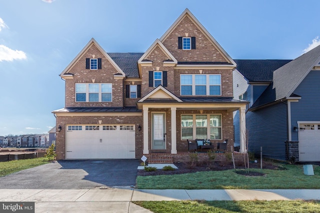 view of front of home featuring a standing seam roof, brick siding, and an attached garage