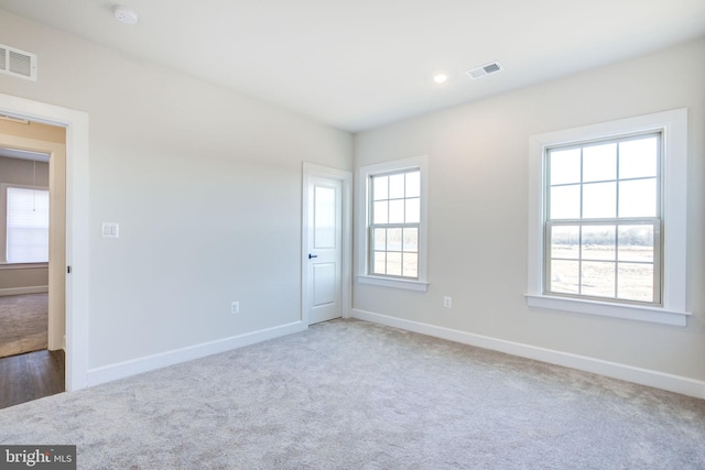 unfurnished room featuring baseboards and visible vents