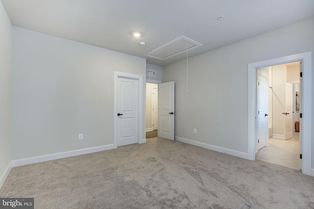 unfurnished bedroom with visible vents, carpet floors, attic access, and baseboards