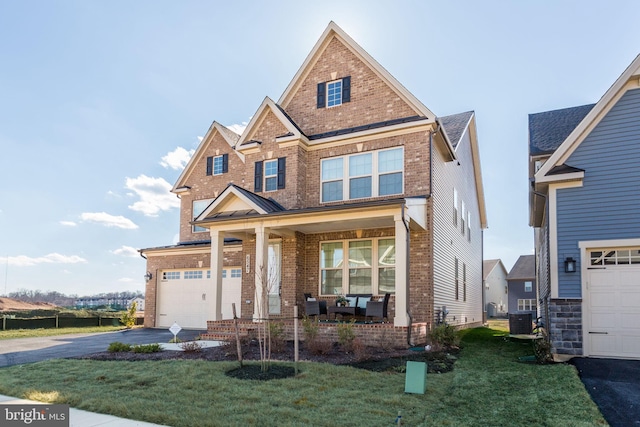 view of front of property featuring a garage, driveway, a porch, a front lawn, and brick siding