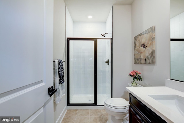 bathroom featuring toilet, a stall shower, vanity, and tile patterned floors