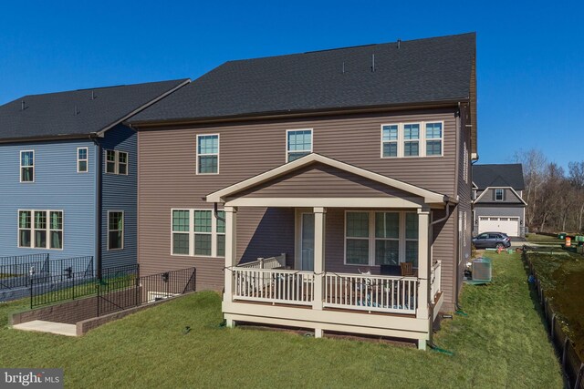 rear view of house featuring covered porch, a lawn, cooling unit, and fence