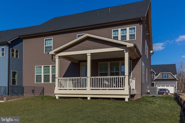 view of front of house with covered porch, a shingled roof, and a front yard