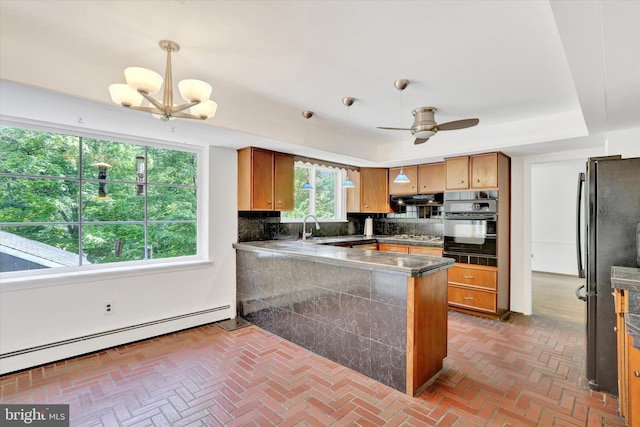 444 Rocksville Rd, Holland, PA 18966 - kitchen featuring baseboard heating, black appliances, backsplash, a peninsula, and under cabinet range hood