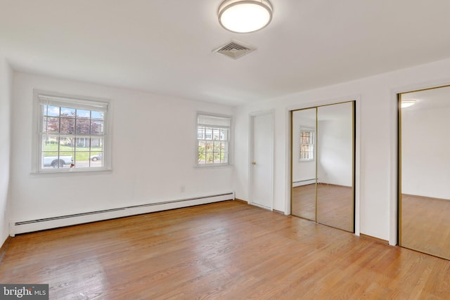 444 Rocksville Rd, Holland, PA 18966 - unfurnished bedroom featuring baseboard heating, multiple closets, multiple windows, and light wood finished floors